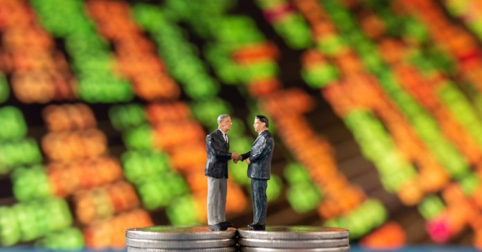 Miniature people , Businessman standing on stack of  Coins with graph display background